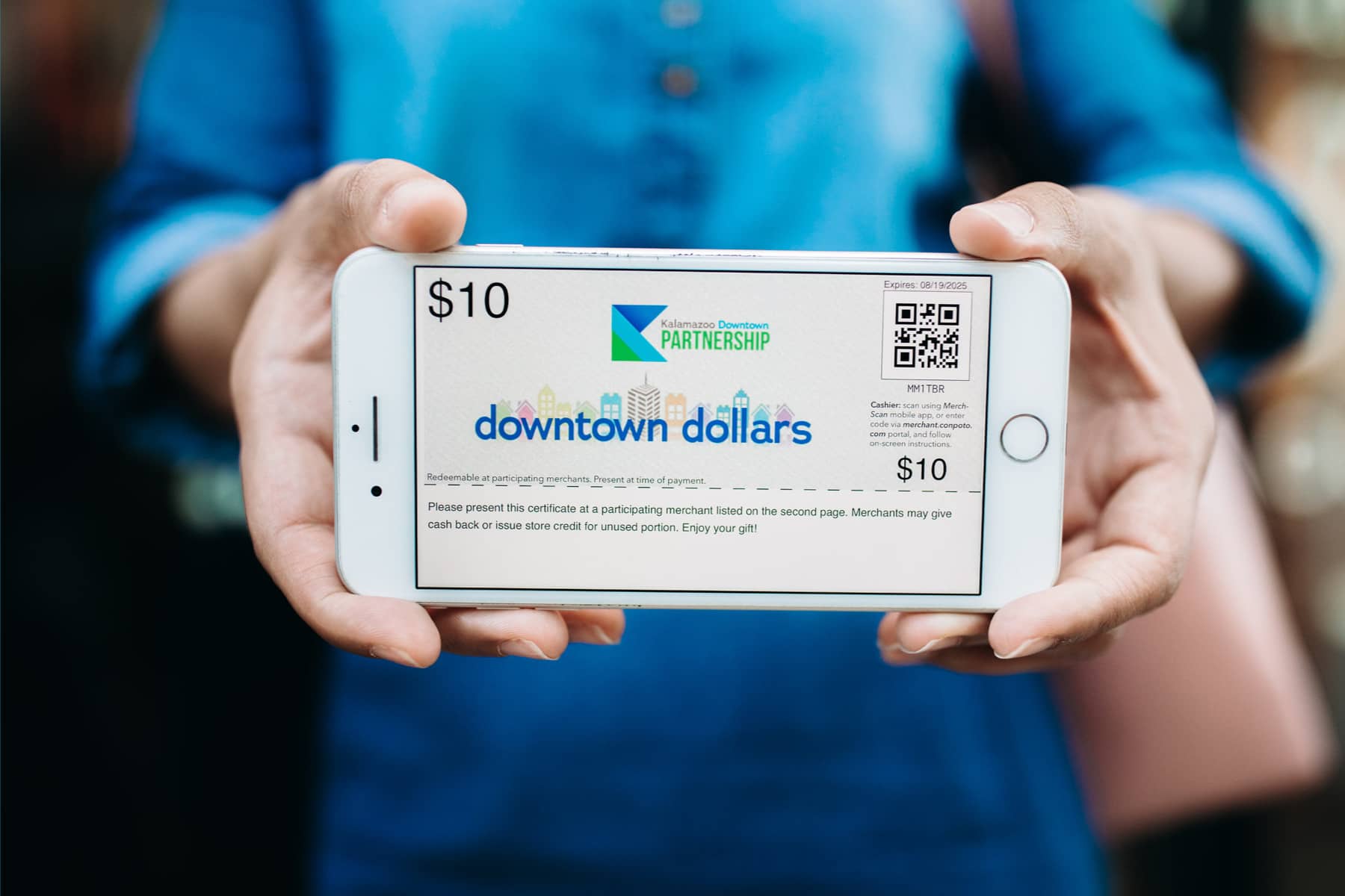  person holding a phone with downtown dollar screen displayed
