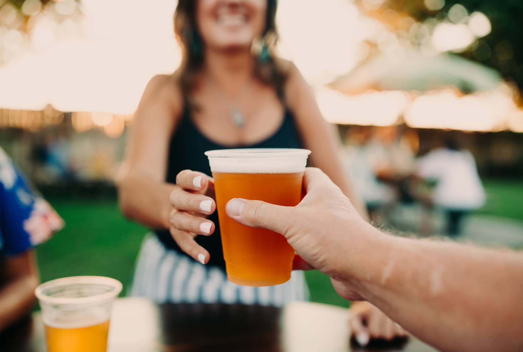  person passing a beer to a woman in Bell's Brewery beer garden