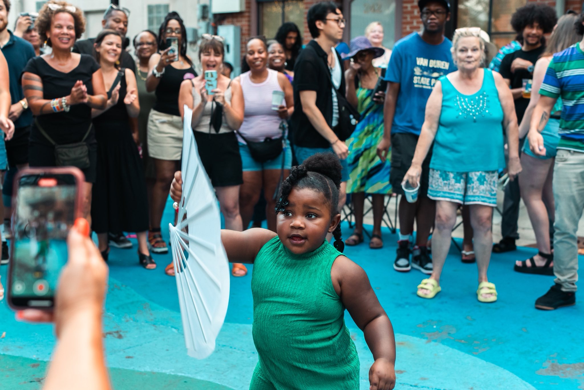  Young girl dancing on Bates Alley surrounded by crowd